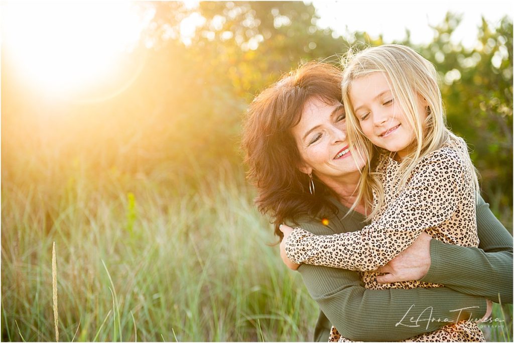 grandmother and granddaughter smile at sunset on LBI beach