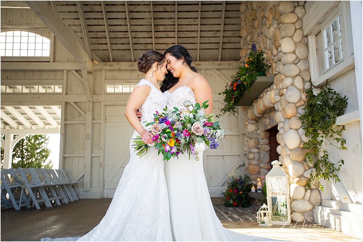 brides lean foreheads together at boat house chapel ceremony space