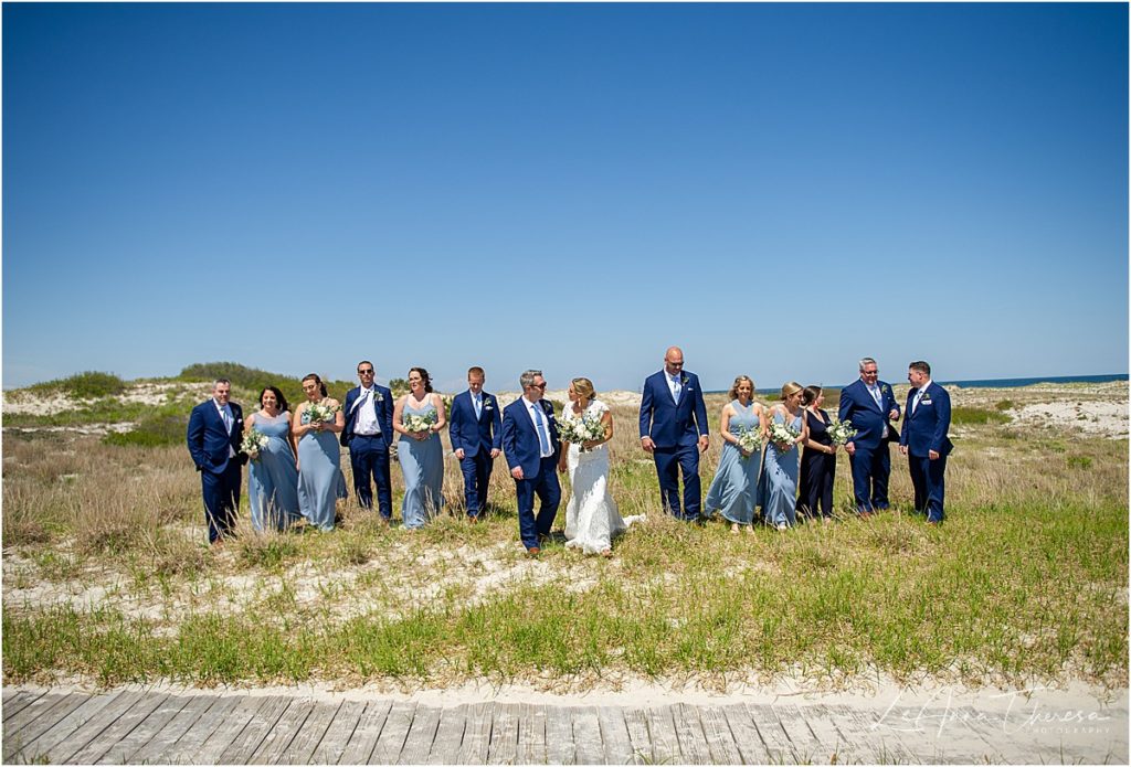 wedding party walking on beach 