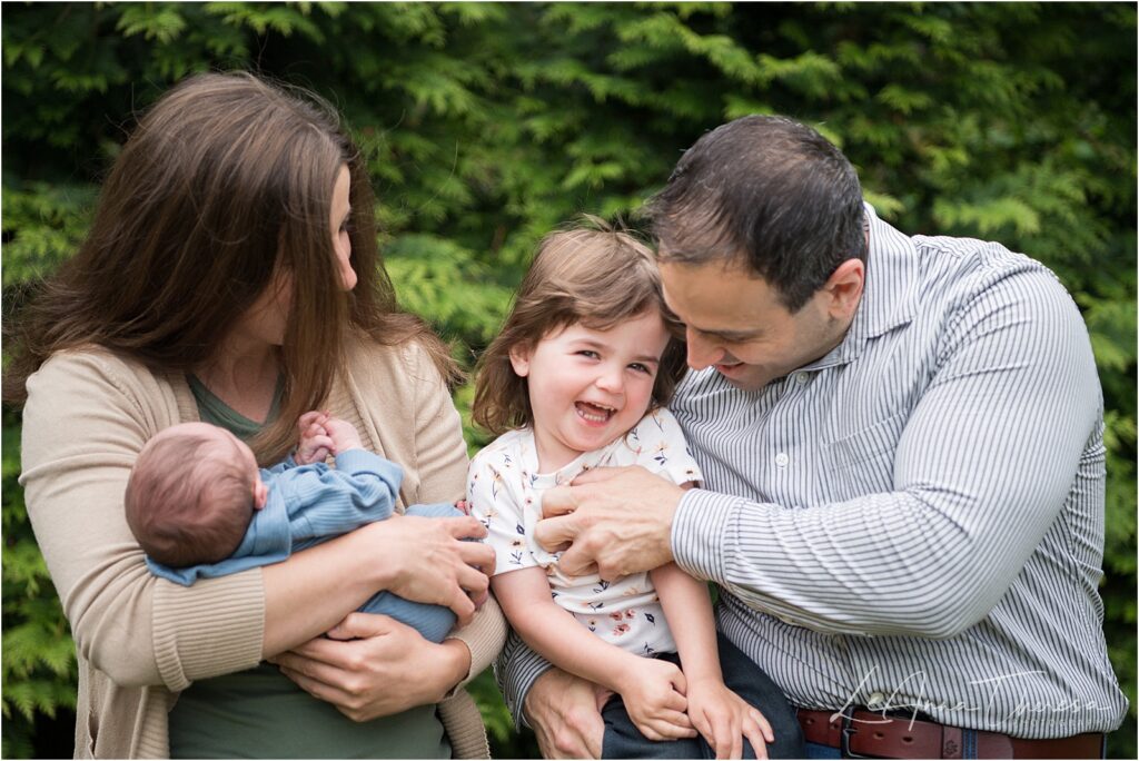 Parents with their toddler daughter and newborn son in the yard of their home in Galloway NJ 