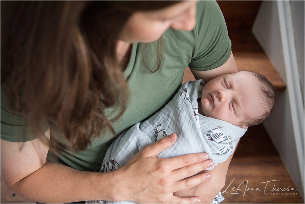 a mother holders her newborn son on the steps of her home for their galloway, nj newborn session